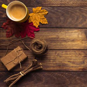 دانلود عکس با کیفیت از میز چوبی و قهوه با تم پاییزی