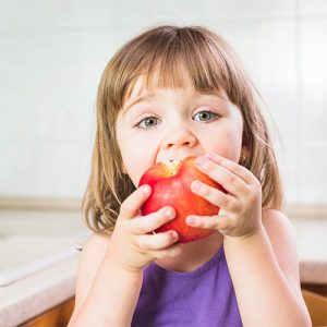 دانلودعکس با کیفیت از دختری زیبا در حال سیب خوردن